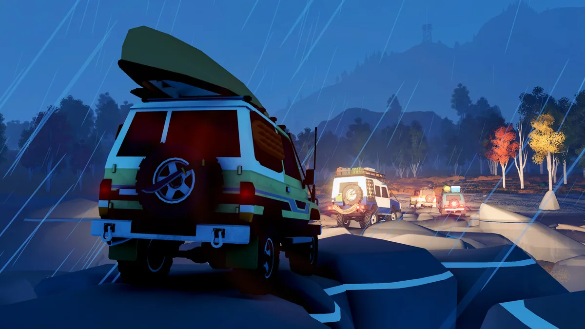 A line of Over the Hill 4x4s with roof racks driving together at night in the rain